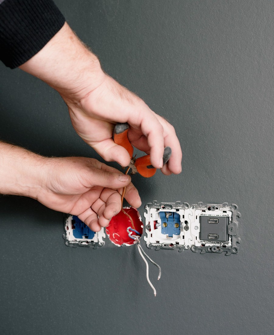 Elektriker bei der Elektroinstallation von Steckdosen am Haus